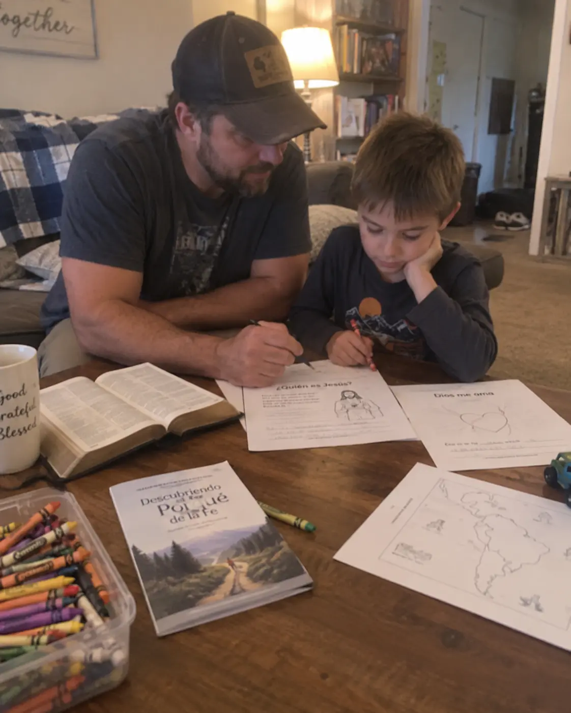 Papá e hijo estudiando con una Biblia y actividades impresas